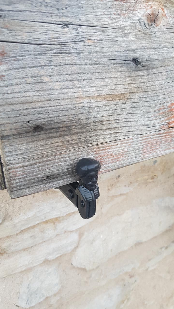 Macro fermapersiana in ferro battuto verniciato nero su persiana in legno antico